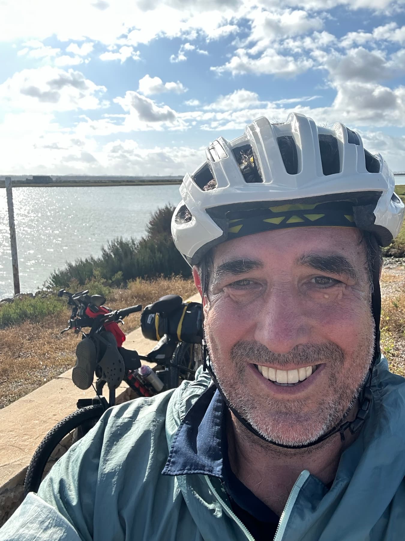 Ángel con casco junto a la bicicleta en una zona de marismas