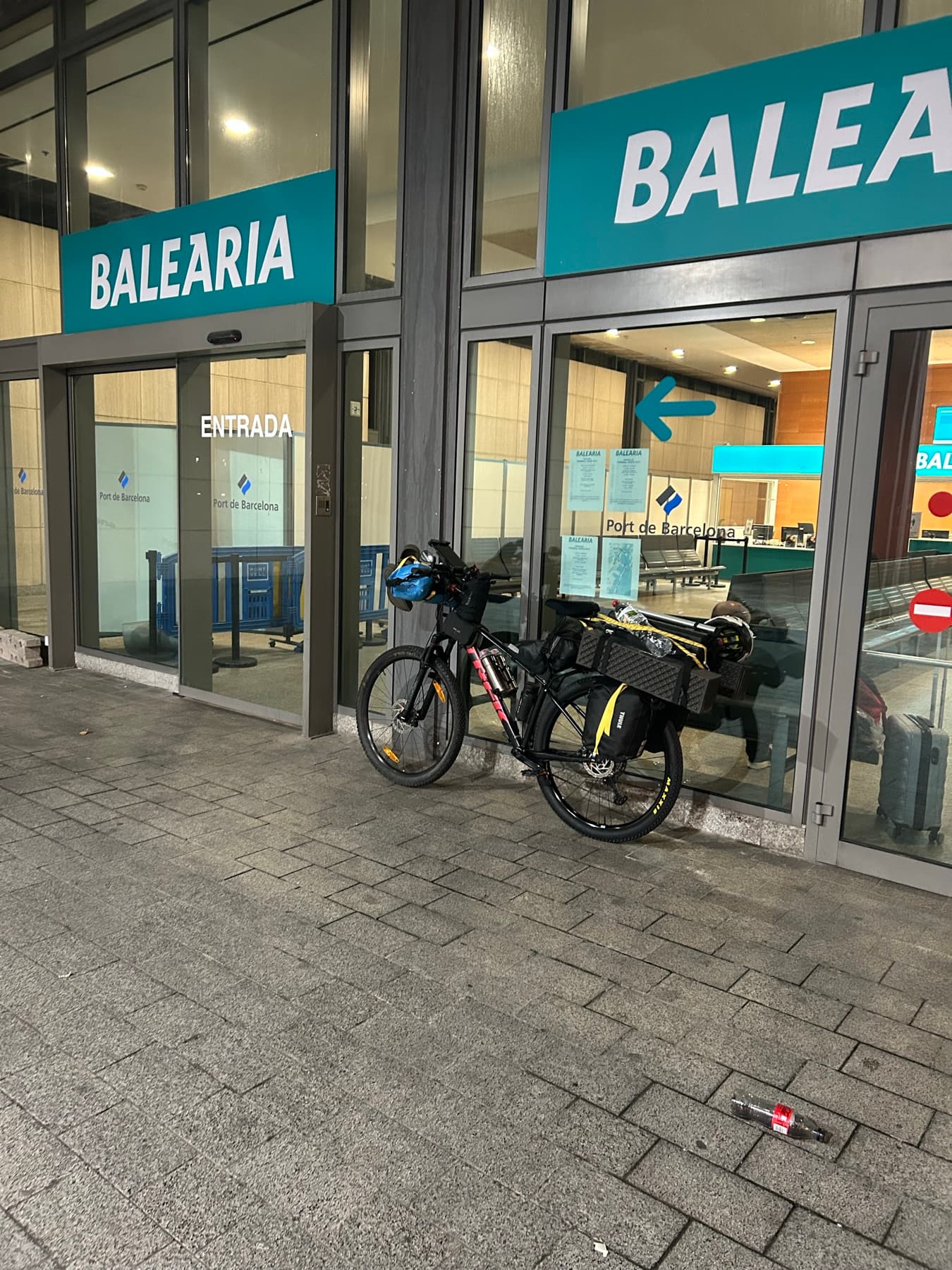 Bicicleta cargada frente a la terminal de Balearia de noche