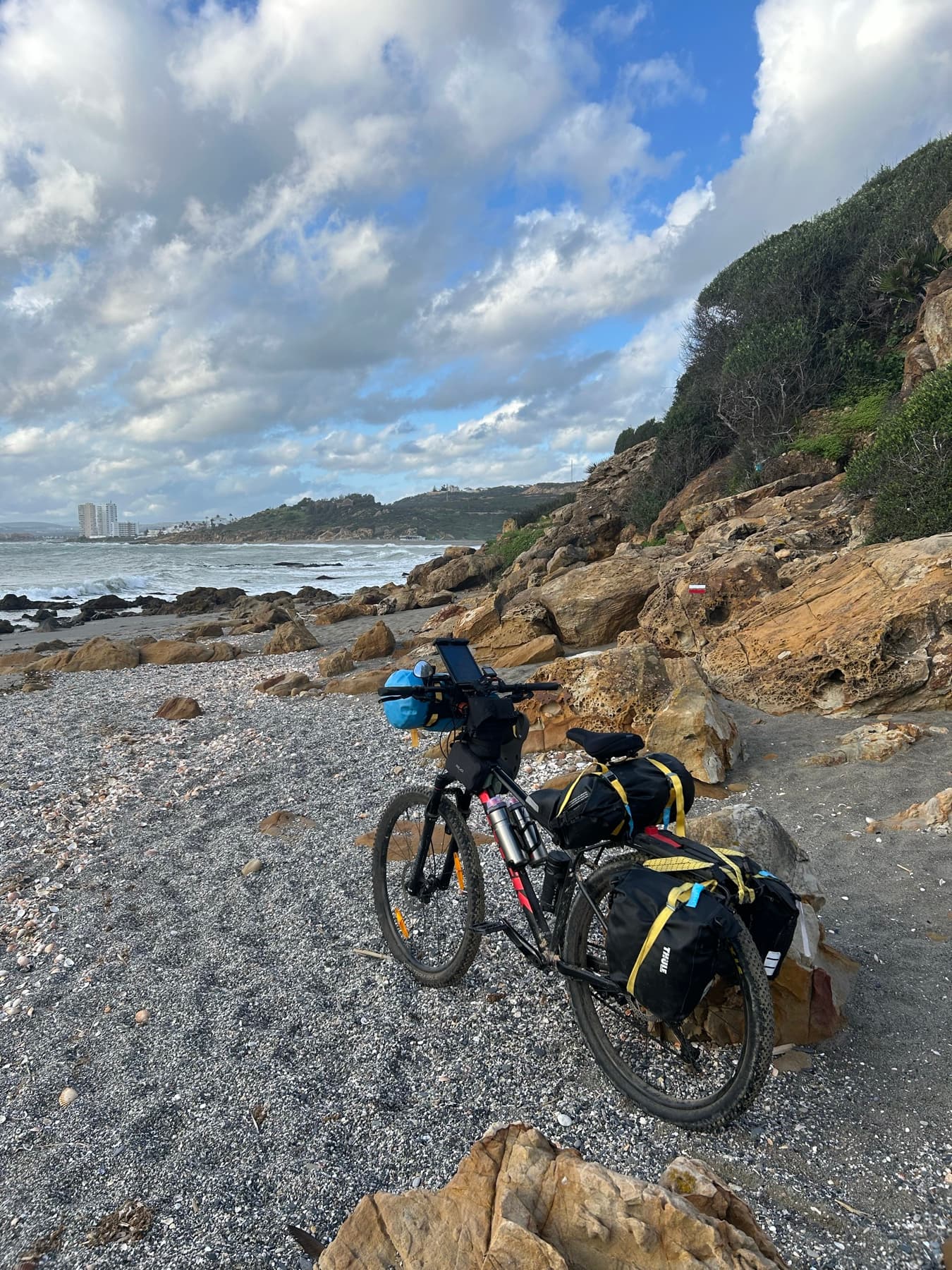 Bicicleta cargada junto a una cala rocosa