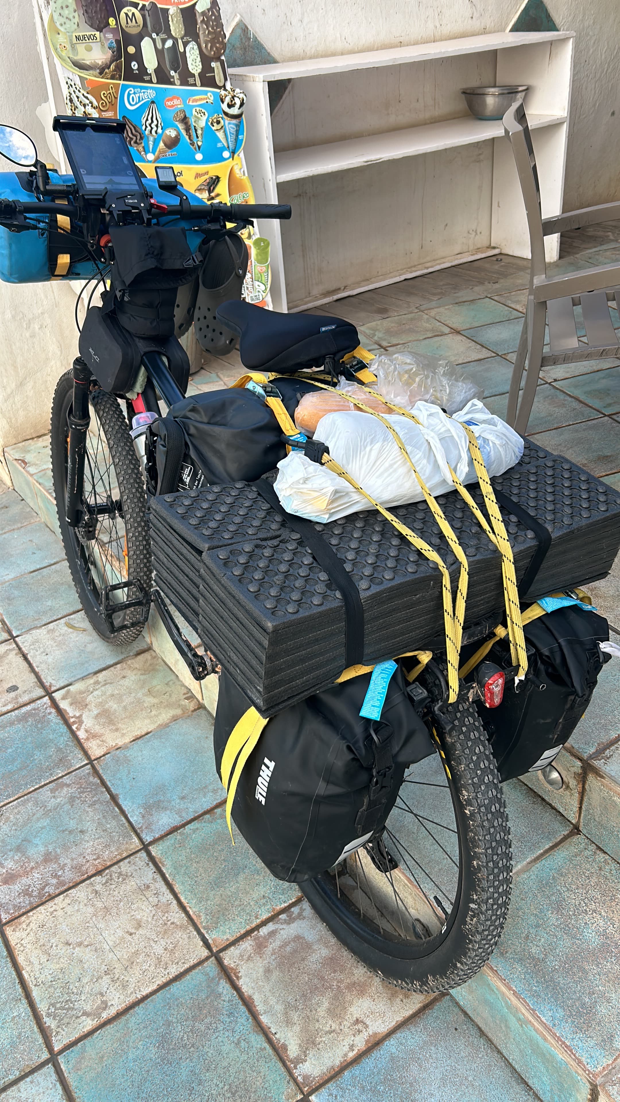 Bicicleta cargada con comida y equipaje atados sobre las alforjas