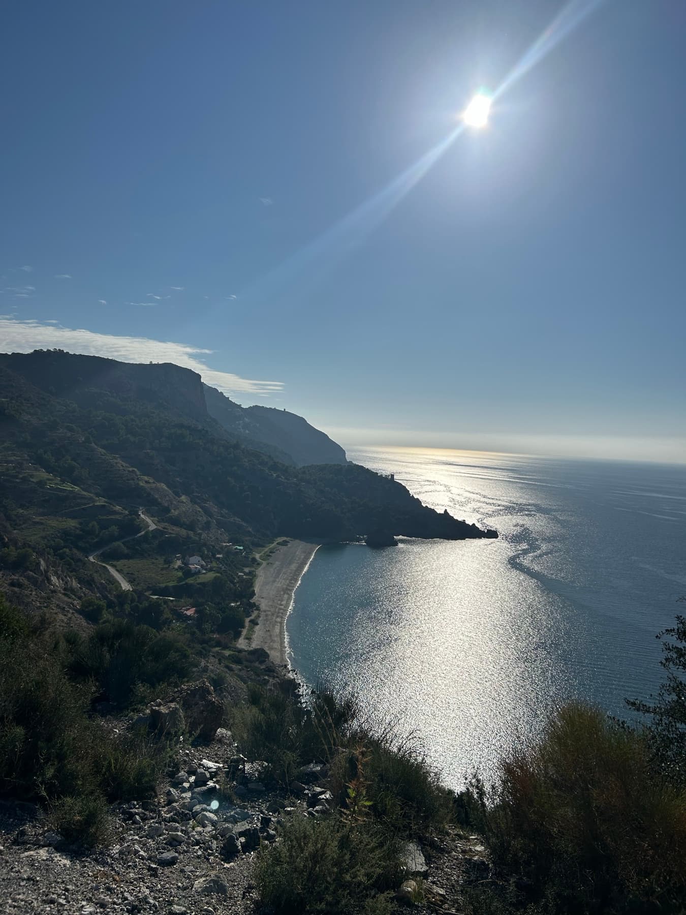 Costa montañosa con luz de tarde sobre el mar