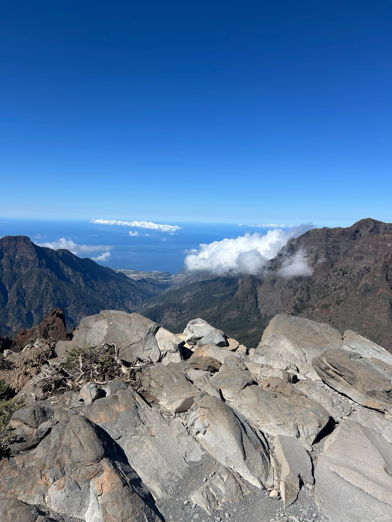 Cumbre rocosa con valle y nubes