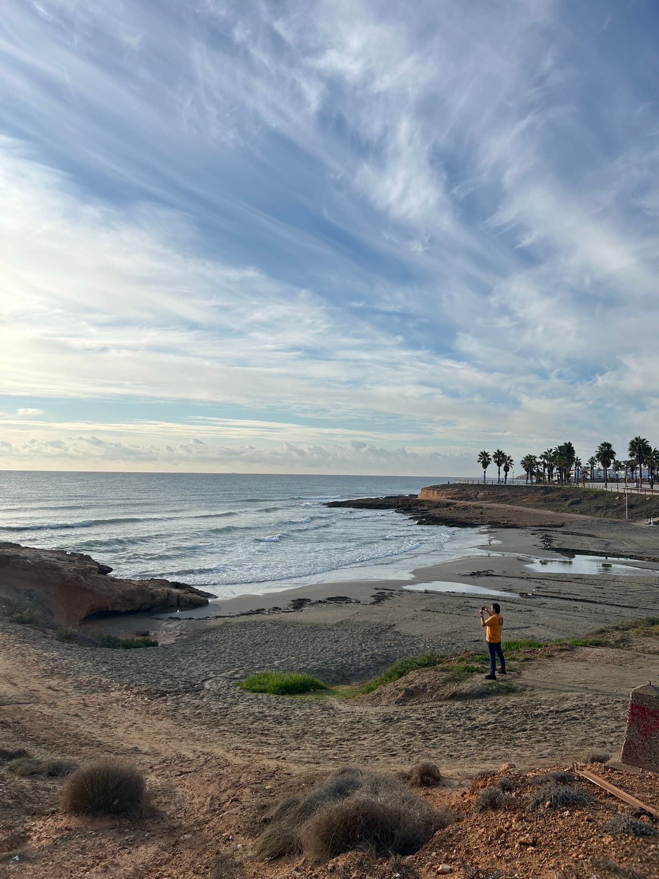 Playa del sur al atardecer con una figura mirando el mar